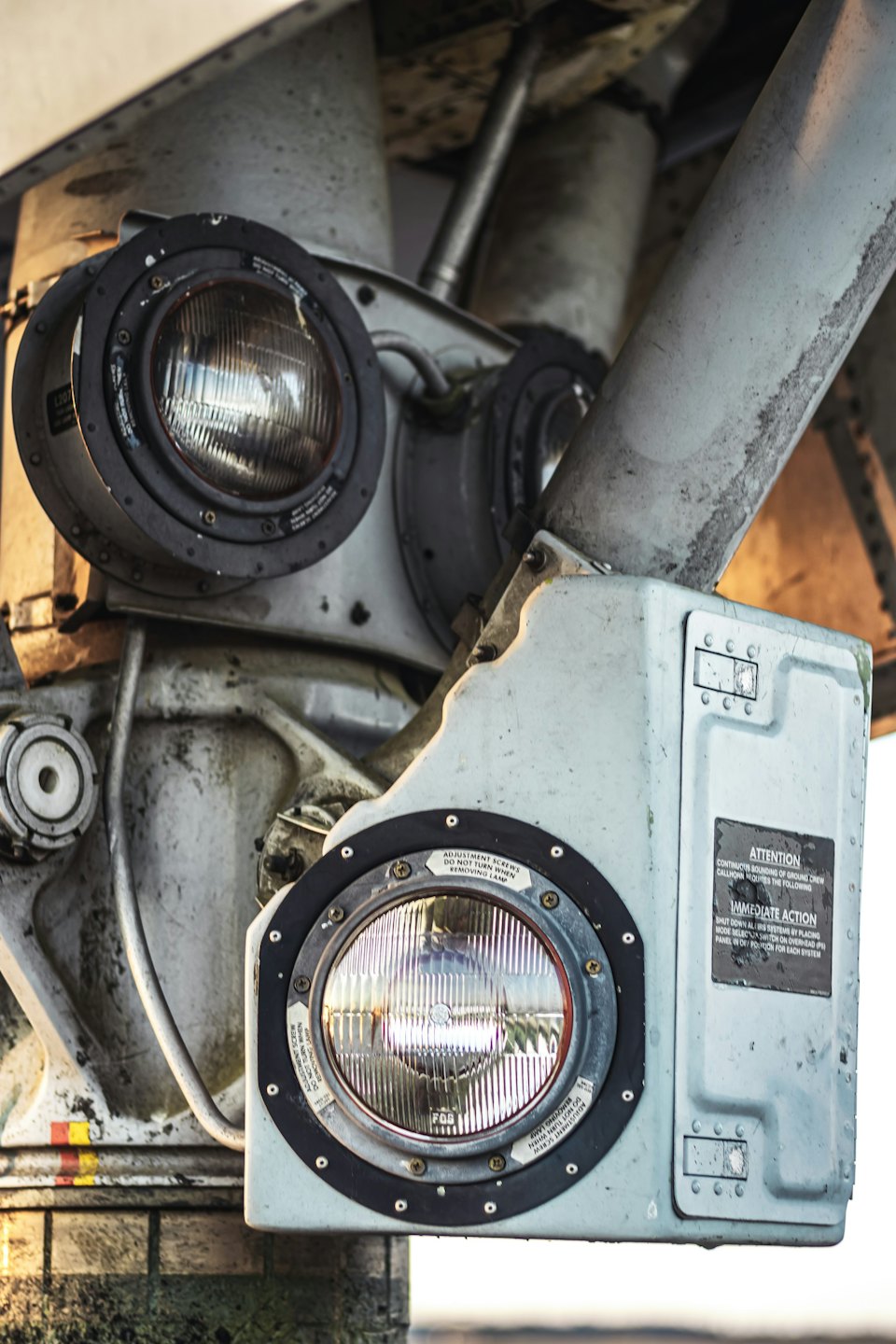 Weathered mechanical aircraft landing gear components with circular lights.