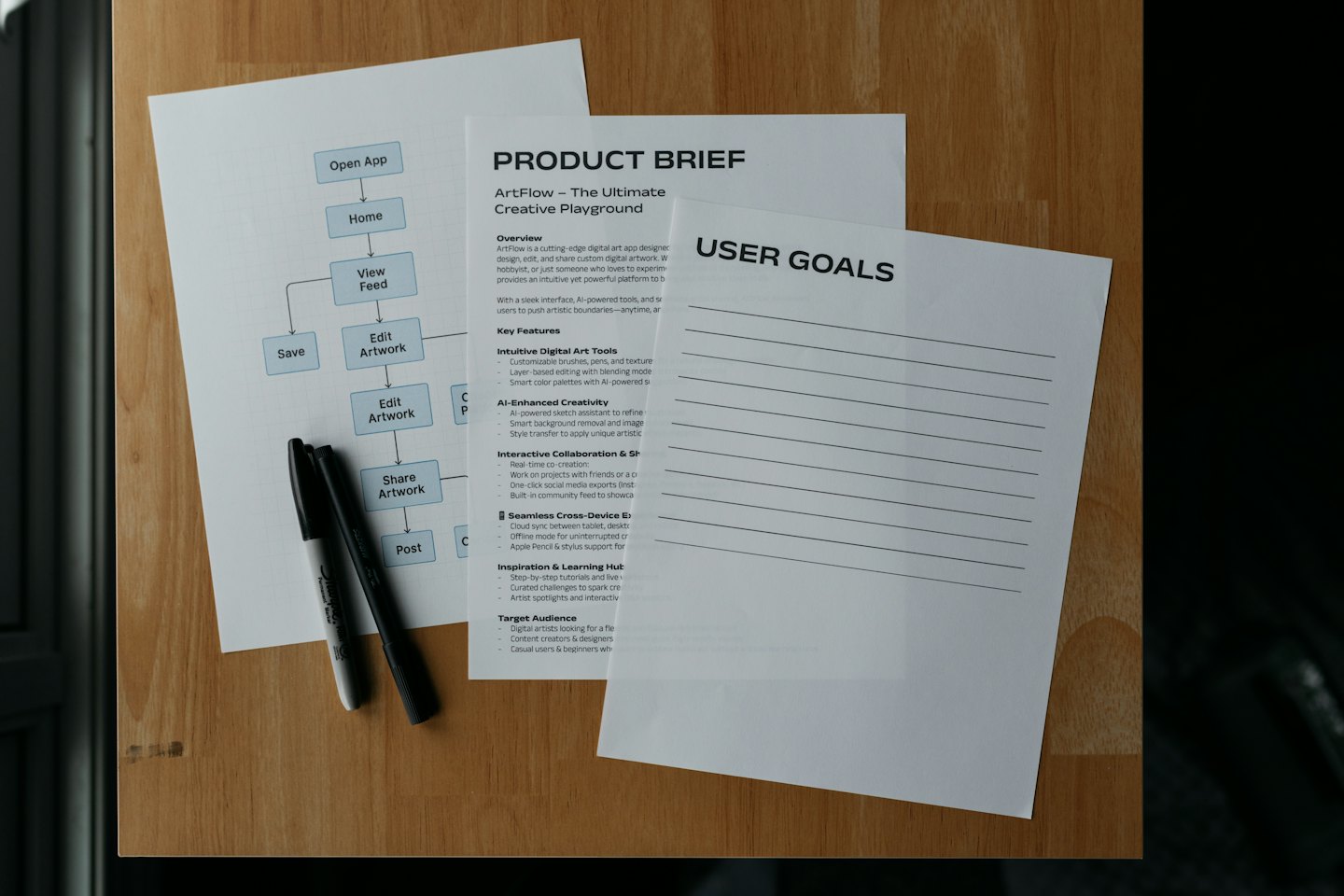 Product development documents laid out on a wooden table.