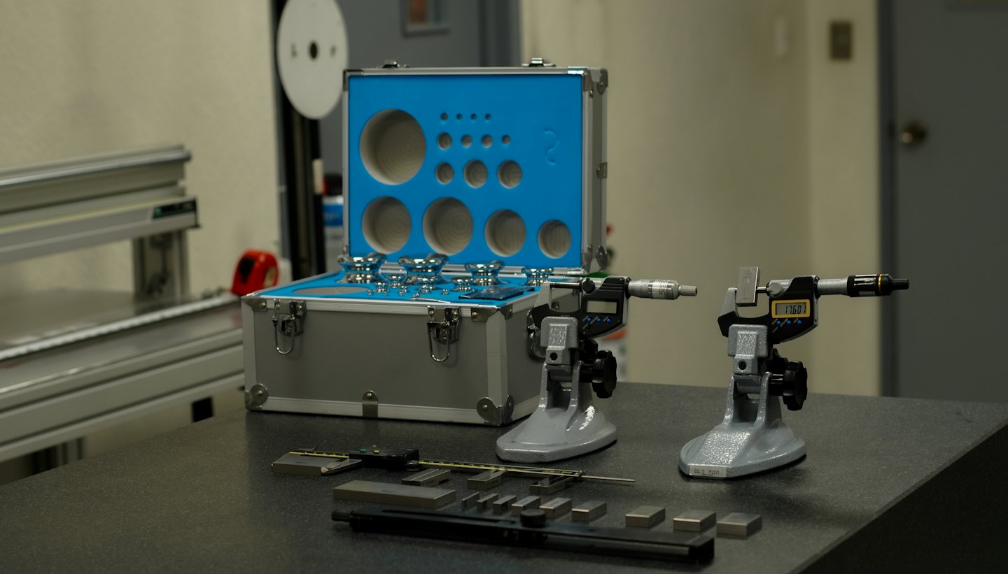 Precision measurement tools and calibration equipment on a workbench.